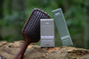 The Complete Growth Ritual: Root Ritual sandalwood scalp brush with Woodland Ritual and Woodland Gaze boxes on a forest log