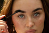 Close-up of the Woodland Gaze spoolie brushing oil through an eyebrow